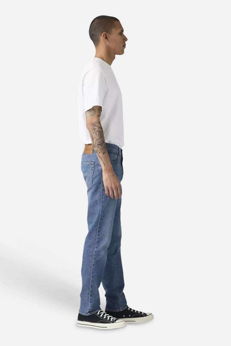 Jean slim fit en denim bleu moyen de Levi's®, porté par un homme, en profil.