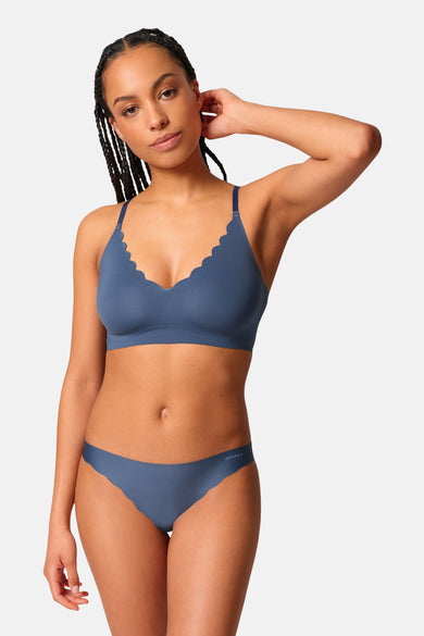 Mauve SKINY, avec une bordure sculptée, portée par un modèle aux cheveux tressés et à la culotte coordonnée.