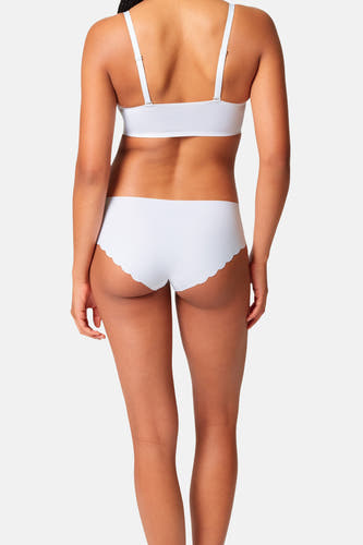 Witte slip van SKINY met geschulpte rand, achterkant, gedragen met een witte beha.