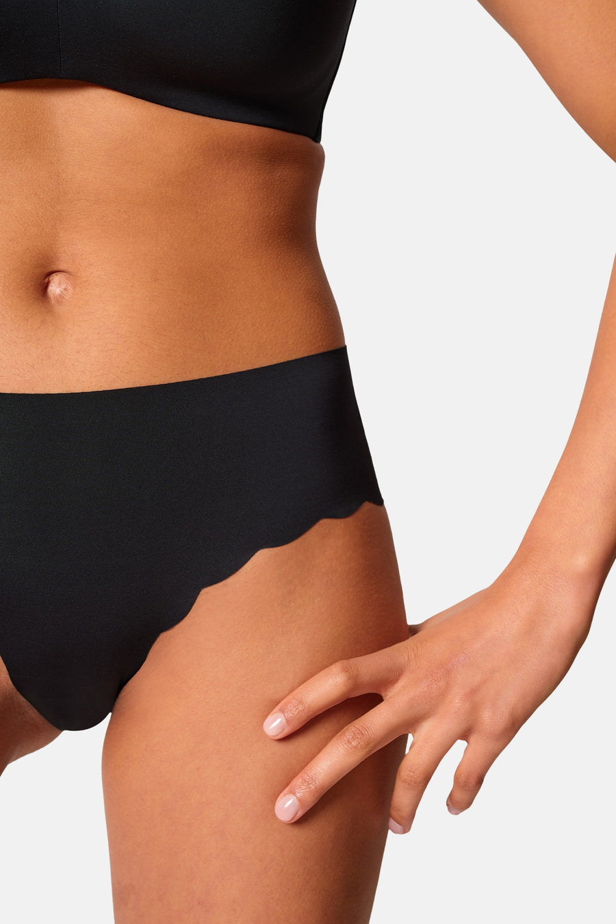 Culotte noire de SKINY à bords festonnés, portée à l'arrière par un mannequin avec un soutien-gorge noir.
