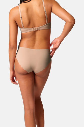 Beige slip van SKINY met geschulpte randen, van achteren gezien op model met bijpassende bh.