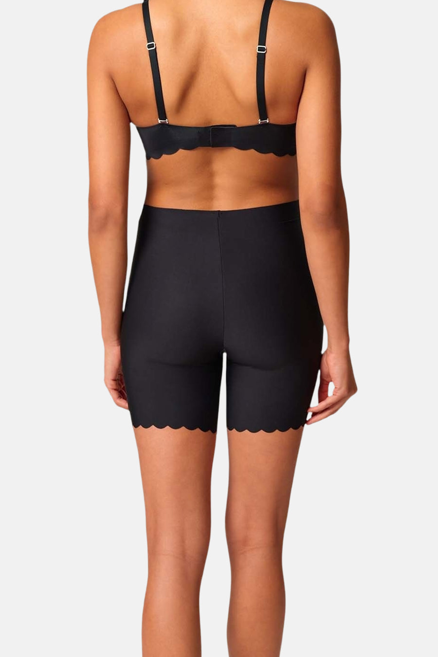 Zwarte shorty van SKINY, met decoratieve geschulpte rand, achterkant gezien, gecombineerd met een bijpassende bh.
