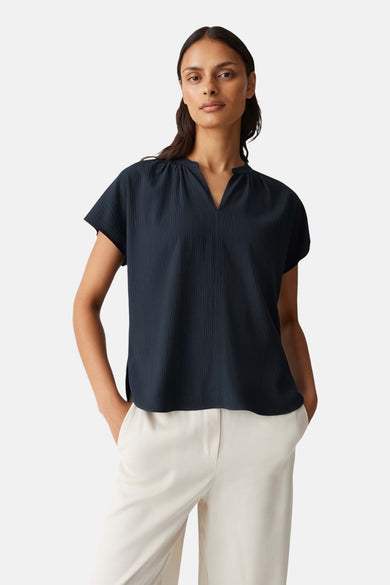 Blouse bleue marine à manches courtes d'OPUS, avec une subtile texture et un col V.