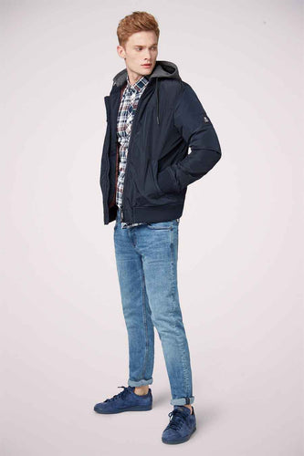 Homme debout en jeans bleus et chaussures de cuir.