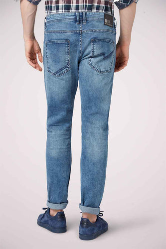 Un homme porte des jeans bleus et des chaussures de cuir bleu.