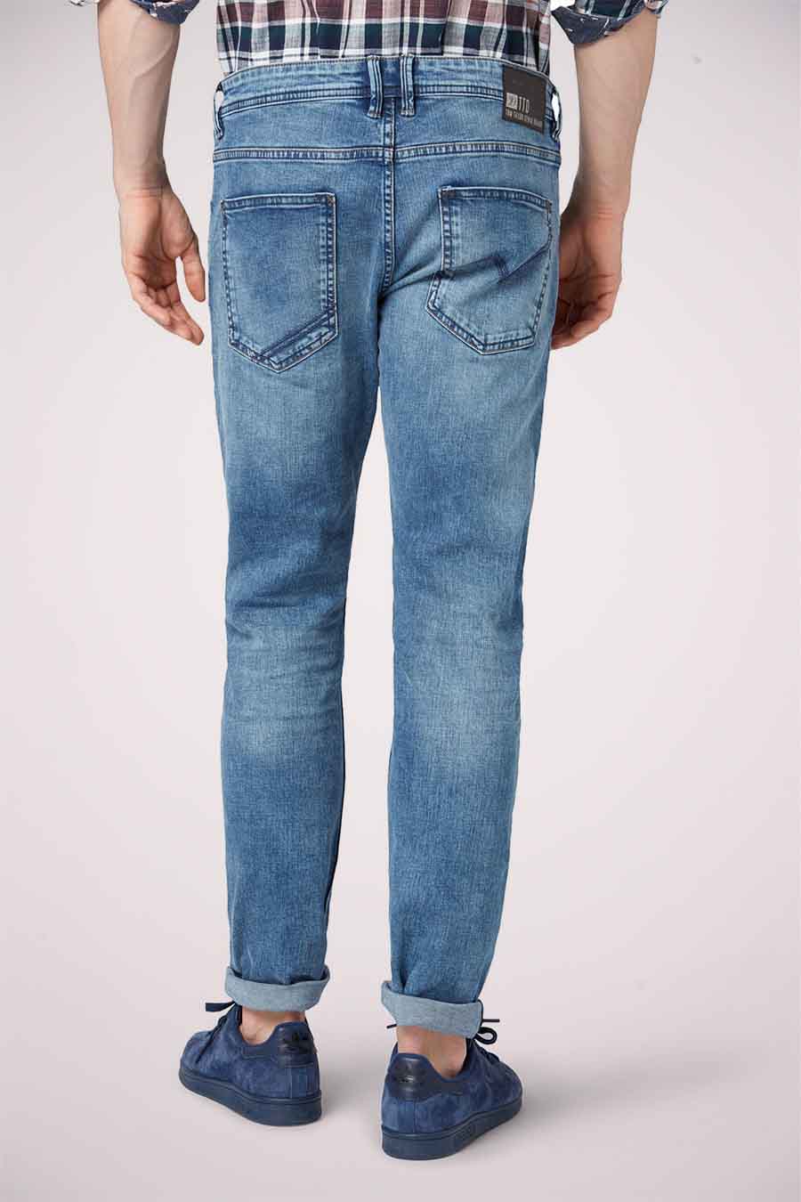 Un homme porte des jeans bleus et des chaussures de cuir bleu.