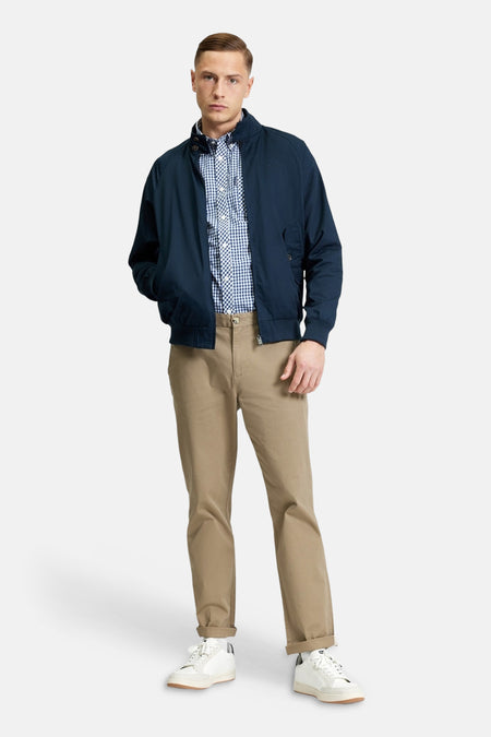 Blauwe korte jas van BEN SHERMAN, met een blauw-wit geruit overhemd en khaki broek.