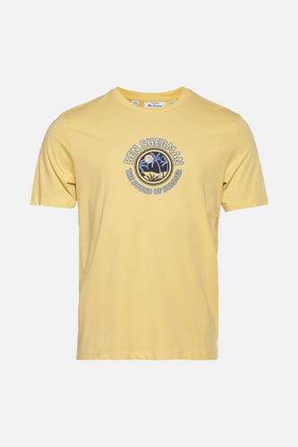 T-shirt jaune à manches courtes de BEN SHERMAN, avec une impression ronde d'arbres à palmes et de texte.