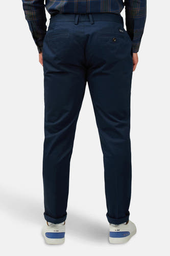 Jean bleu de BEN SHERMAN, vu de derrière avec des jambes relevées et des baskets blanches.