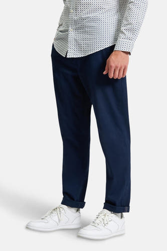 Chino bleu de BEN SHERMAN, avec des poches rabattues et associé à une chemise blanche imprimée.