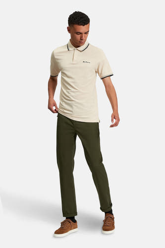 Chino vert de BEN SHERMAN, associé à un poloshirt crème et des chaussures en cuir marron.