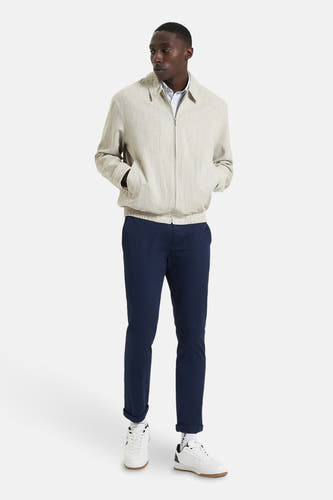 Beige korte jas van BEN SHERMAN, gedragen met een blauwe broek en witte sneakers.