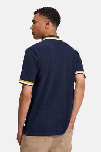 Polo bleu à manches courtes de BEN SHERMAN, avec des rayures blanches et jaunes sur le col et les manches.