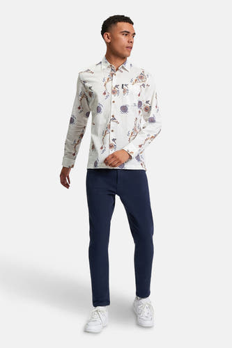 Chemise multicolore à longues manches de BEN SHERMAN, avec un motif floral voyant, associée à des pantalons bleu marine et des baskets blanches.