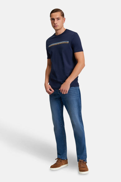 T-shirt bleu à manches courtes de BEN SHERMAN, avec des détails rayés sur la poitrine, associé à des jeans et des chaussures marrons.
