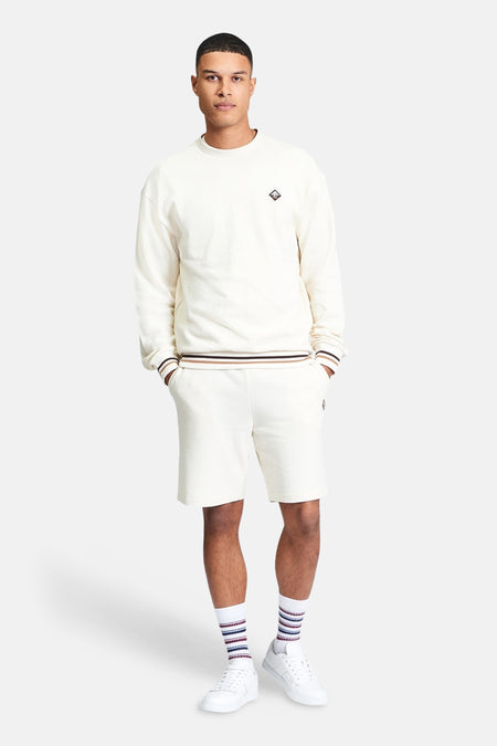 Ecru sweater van BEN SHERMAN, met een logo op de borst en gestreepte manchetten.