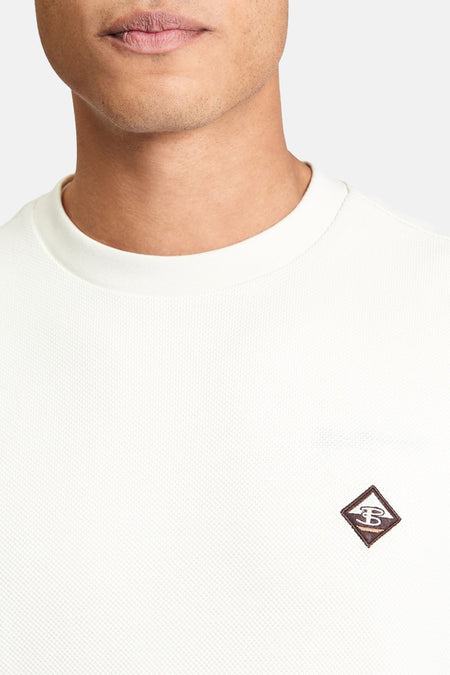 Pull écru de BEN SHERMAN avec un col rond et un petit logo sur la poitrine.