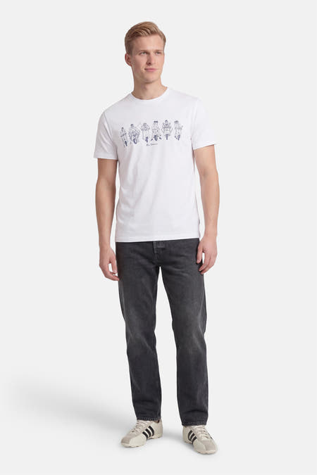 T-shirt blanc Ben Sherman, avec un imprimé de scooters et porté avec un jean gris et des baskets.
