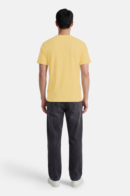 T-shirt jaune à texture fine de BEN SHERMAN, vue arrière, associé à un jean gris foncé et des baskets blanches.