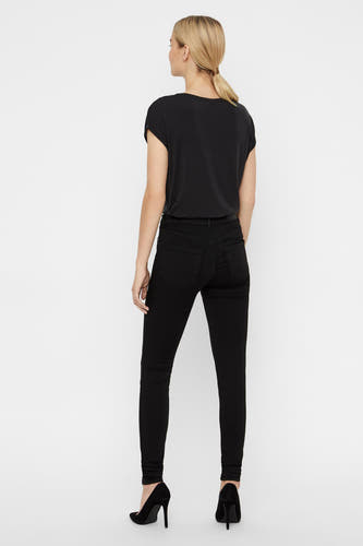 Jean skinny noir en denim de Vero Moda, vu de de derrière avec un t-shirt noir et des baskets noires.