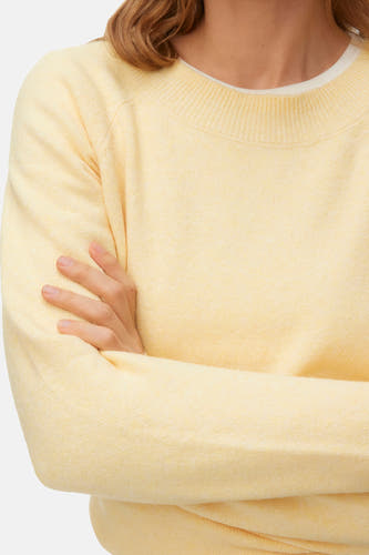 Pull jaune à col rond de Vero Moda, avec bras croisés et texture douce.