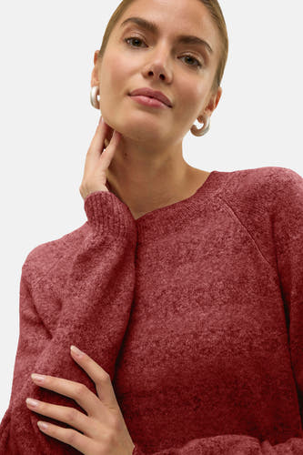 Pull rond rouge V V de Vero Moda, avec des manches longues, porté avec des boucles d'oreilles en argent.