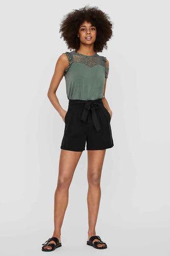 Short noir de VERO MODA®, avec une ceinture à la taille et porté avec un haut vert.