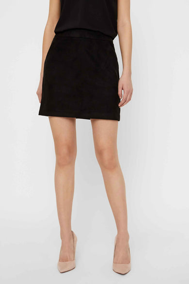 Jupe courte noire de VERO MODA, portée avec des escarpins beige.