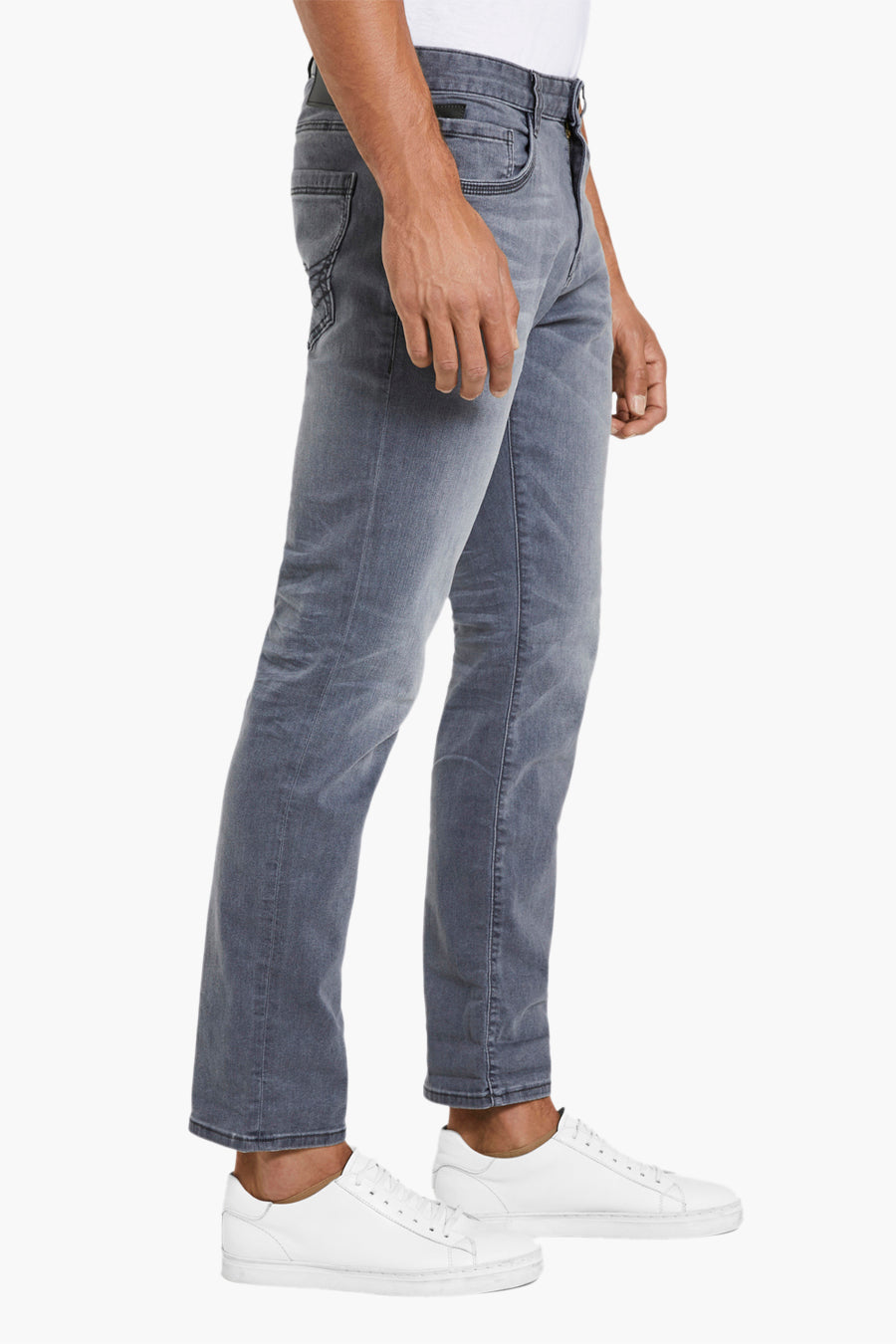 Grijze jeans en witte sneakers.