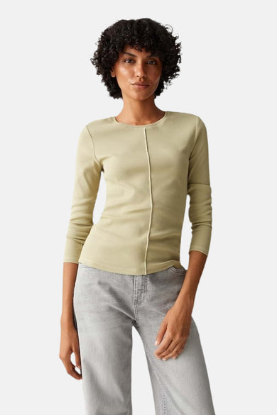 Pull vert de col col r OP OP OPUS, avec long long long et une couture verticale à l'avant, porté avec un pantalon gris.