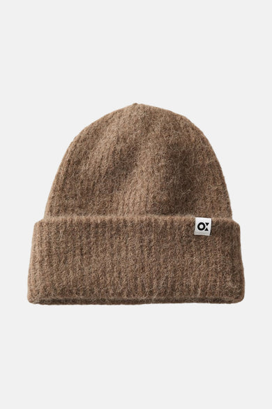 Chapeau brun d'OPUS porté par une femme blonde avec un manteau teddy brun.