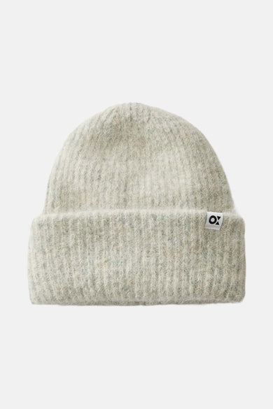 Chapeau vert d'OPUS, avec une fine texture tricotée et un petit étiquette sur le côté.