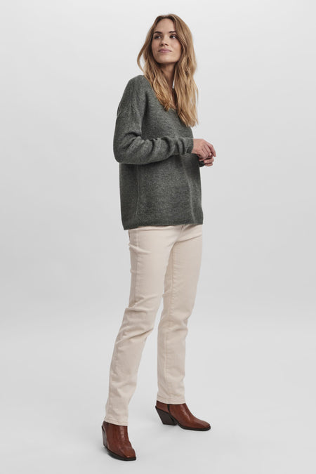 T-shirt vert avec col V de Vero Moda, à longues manches, associé à un pantalon beige et des bottes brunes.