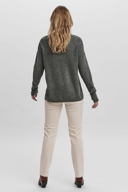 T-shirt V-hals vert deEROERO MODAA, vu der arrière avec avec pantalon crème et des bottes brunes.