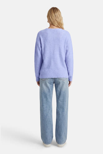Pull bleu à col en V de Vero Moda, à manches longues, combiné avec un jean ample.