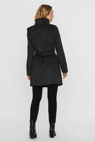 Grijze jas van VERO MODA, gezien van achteren, met een ceintuur en zwarte broek en laarzen.
