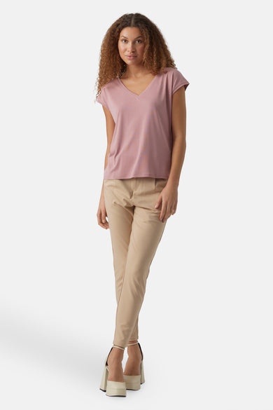 T-shirt rose à manches courtes de VERO MODA, associé à une pantalon beige et des baskets blanches.