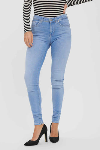 Jean skinny en denim bleu clair de Vero Moda, avec une taille haute et des talons noirs.