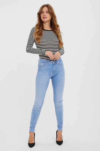 Lichtblauwe skinny jeans van Vero Moda, met een gestreept shirt en zwarte pumps.
