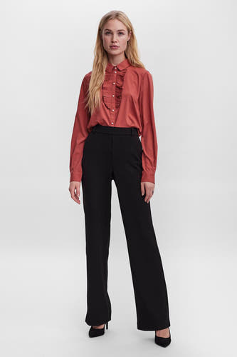 Pantalon noir de VERO MODA, avec des jambes larges et une ceinture ajustée, associé à une blouse rouille avec des plis.