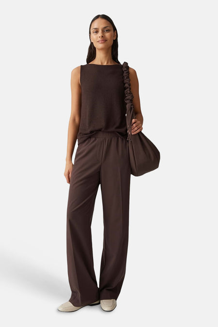 Bruine top zonder mouwen van OPUS, gecombineerd met bruine pantalon en een bruine tas over de schouder.