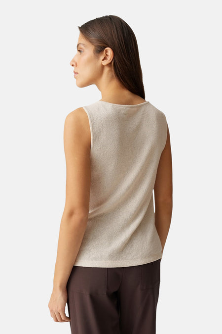 Beige top zonder mouwen van OPUS, met een subtiele textuur en gecombineerd met een bruine broek.