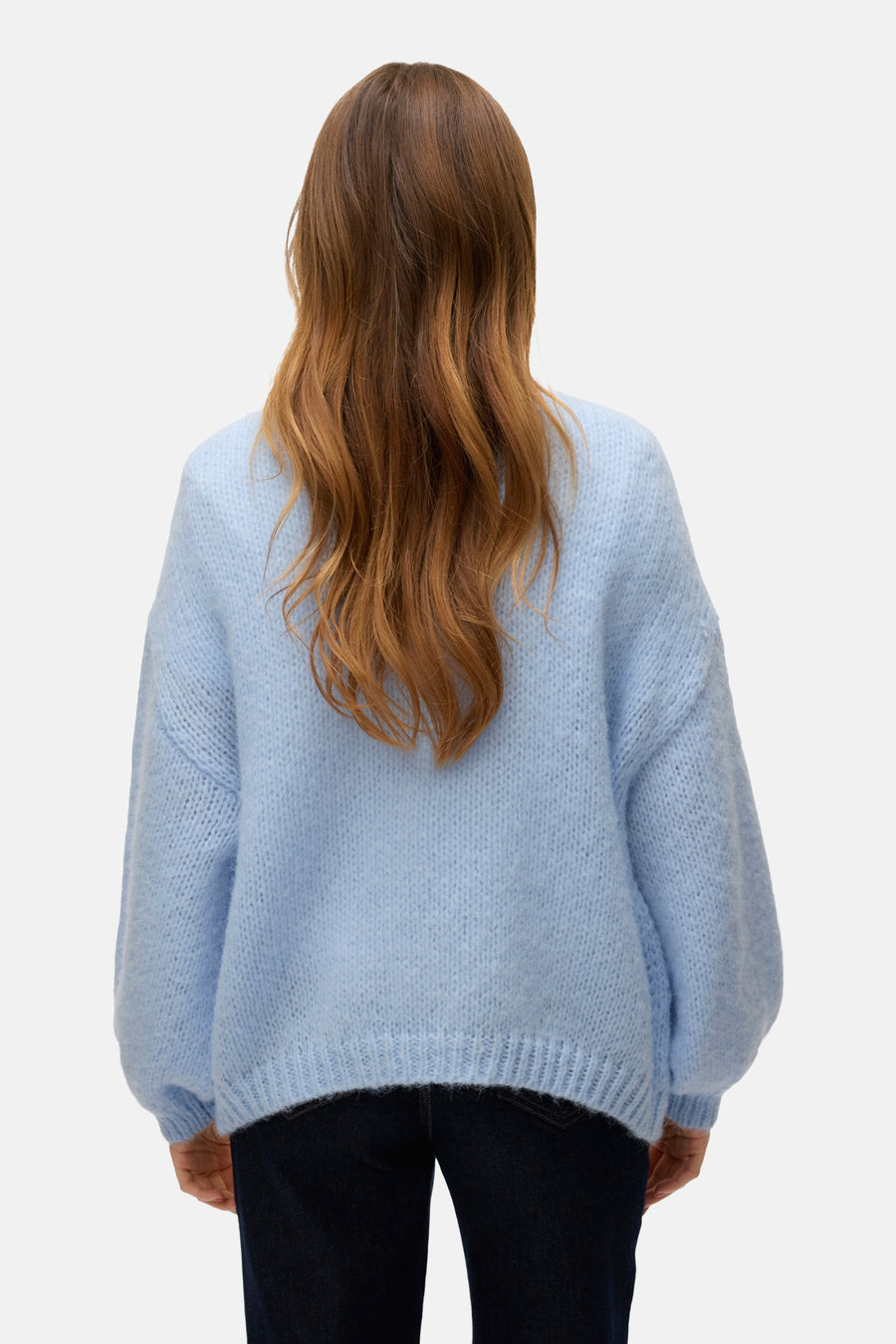 Cardigan bleu de VERO MODA, vu du dos, avec des manches bouffantes et une douce texture, porté sur un pantalon de travail noir.