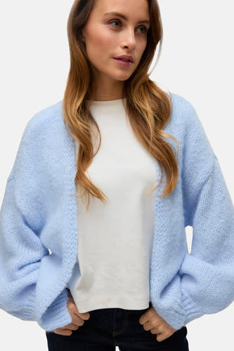 Cardigan bleu de Vero Moda, avec une fermeture avant ouverte et des manches longues, porté sur un t-shirt blanc.
