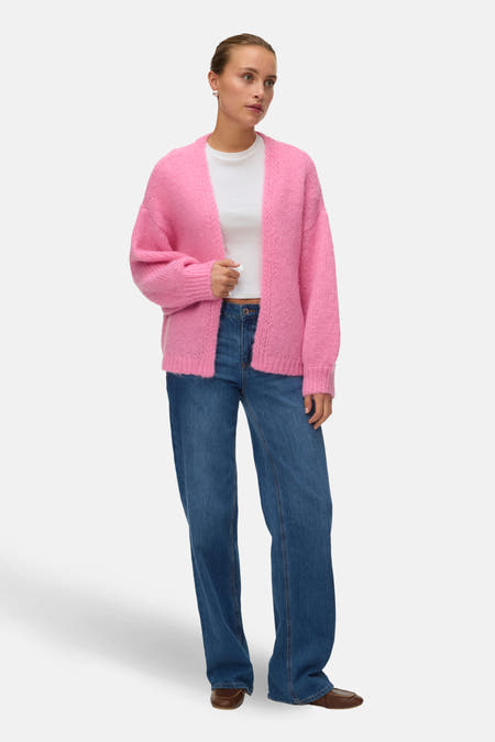 Cardigan rose de Vero Moda, avec une douce texture tricotée, associé à un jean bleu.