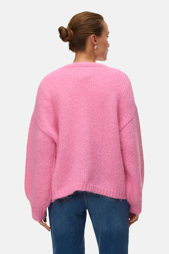 Roze cardigan van Vero Moda, met een zachte gebreide textuur, gecombineerd met een blauwe jeans.
