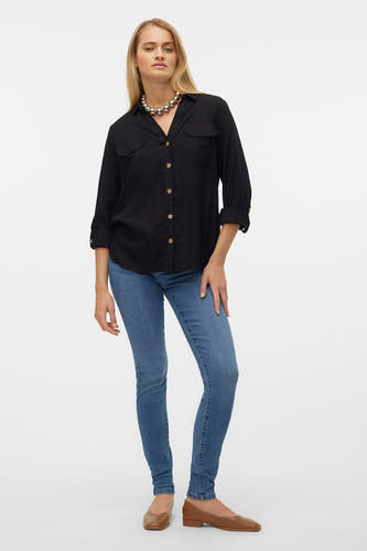 Chemise noire à manches longues de VERO MODA®, avec boutons dorés, combinée avec un jean bleu et des chaussures brunes.