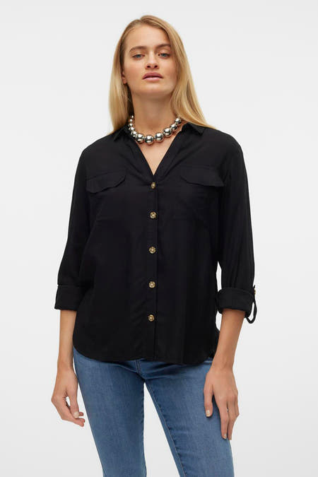 Chemise noire à manches longues de VERO MODA, avec poches de poitrine, boutons dorés et une chaîne de col argentée.