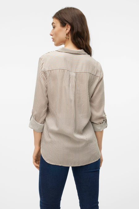 Chemise rayée marron avec longues manches de VERO MODA®, visible sur le dos avec des manches retroussées et un jeans foncé.