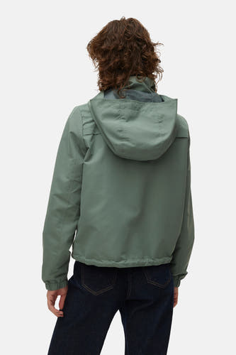 Veste courte verte de Vero Moda, avec capuche et jean bleu foncé visible.